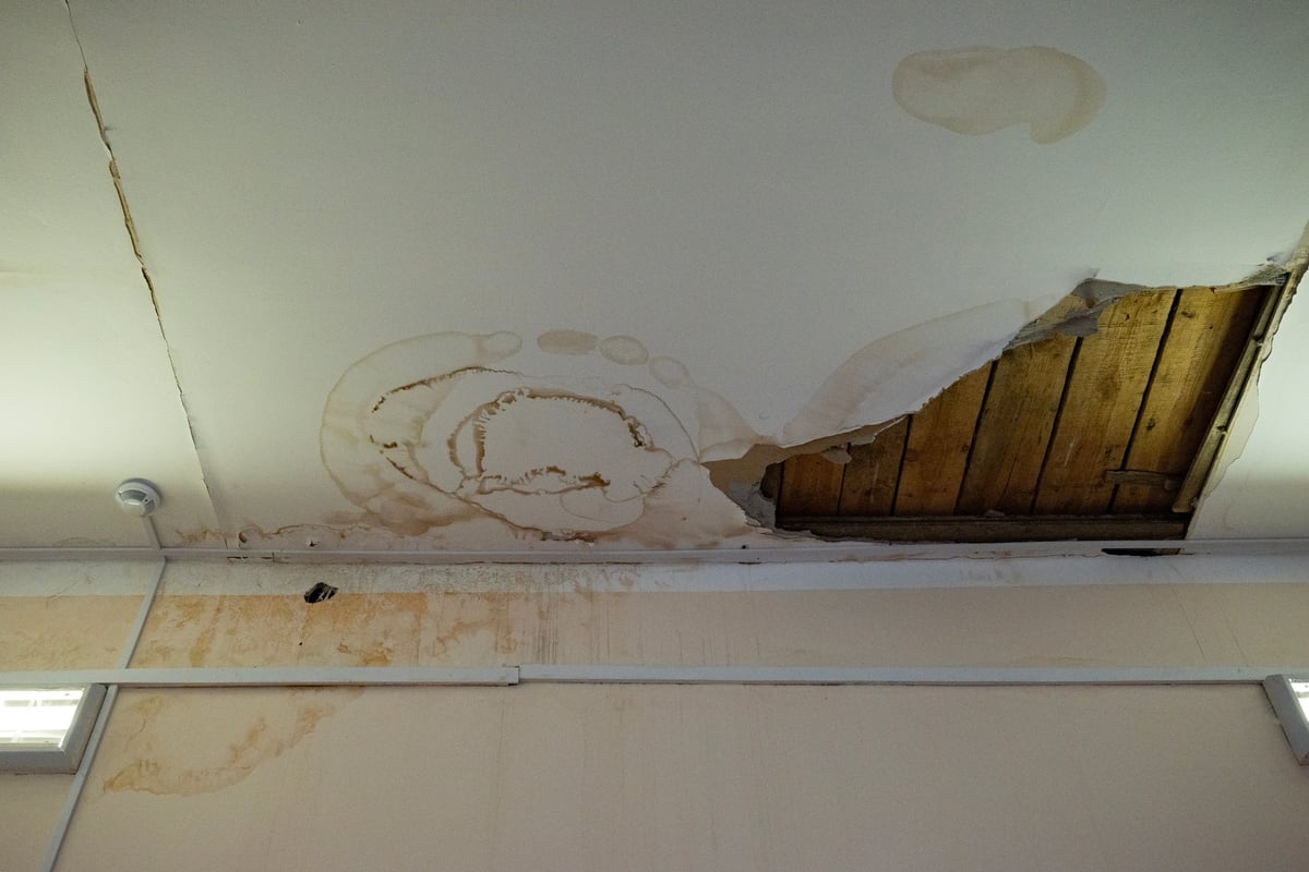 Flooding rainwater causing interior damage, peeling paint and mildew