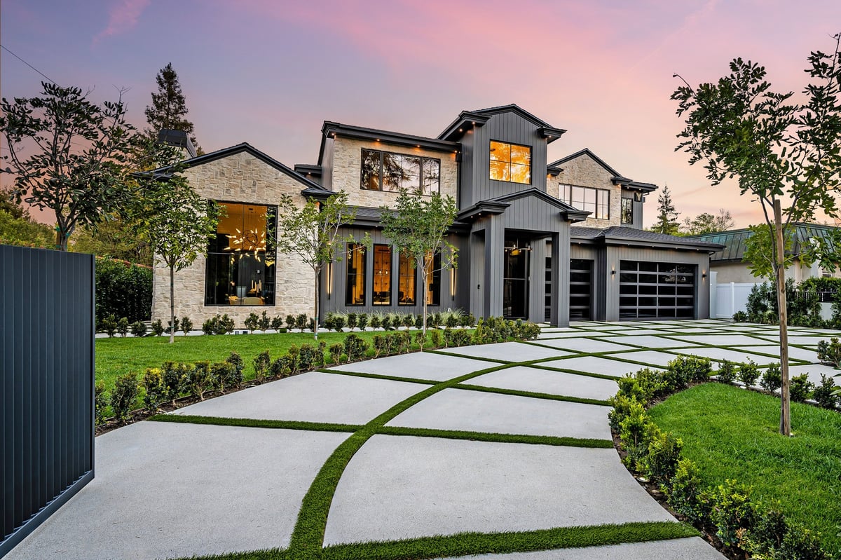 Modern residential home exterior with manicured lawn at dusk
