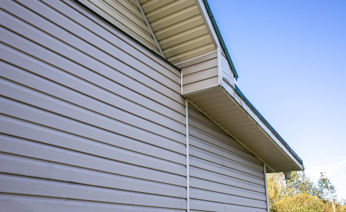 Residential house facade with clean siding under a clear blue sky