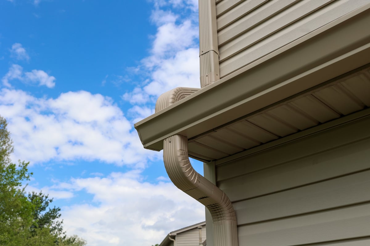 Clean professionally installed gutter and downspout system on a residential home